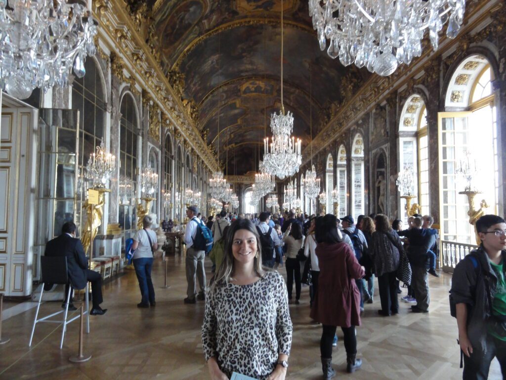 Uma Magu deslumbrada por uma das principais salas do Palácio de Versalhes: a Sala dos Espelhos