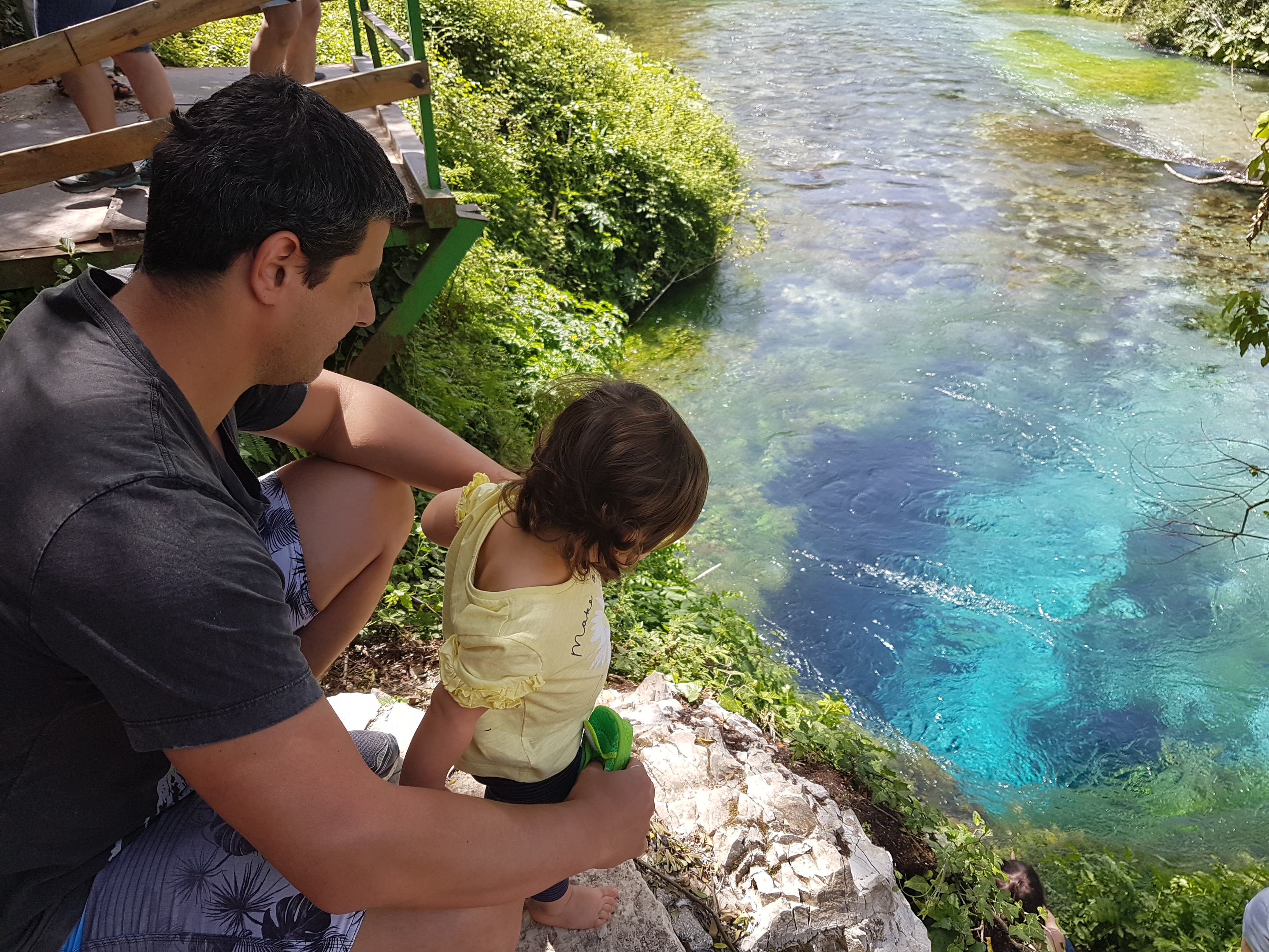 Um pai e uma filha "peixes" calculando os riscos de um mergulho no Olho Azul na Albânia