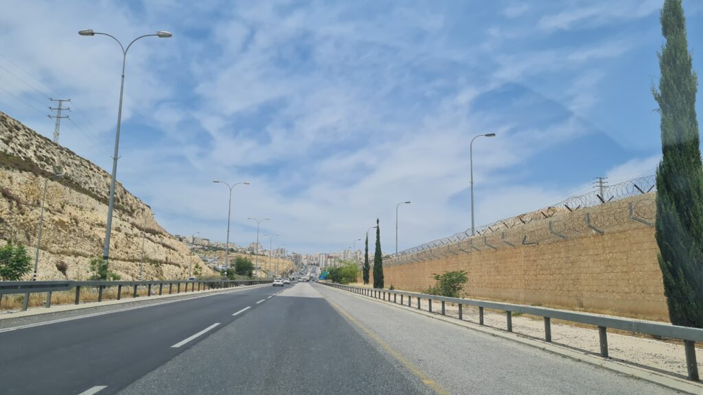 Estradas que cortam a Palestina são cercadas e protegidas por muros e homens armados.
