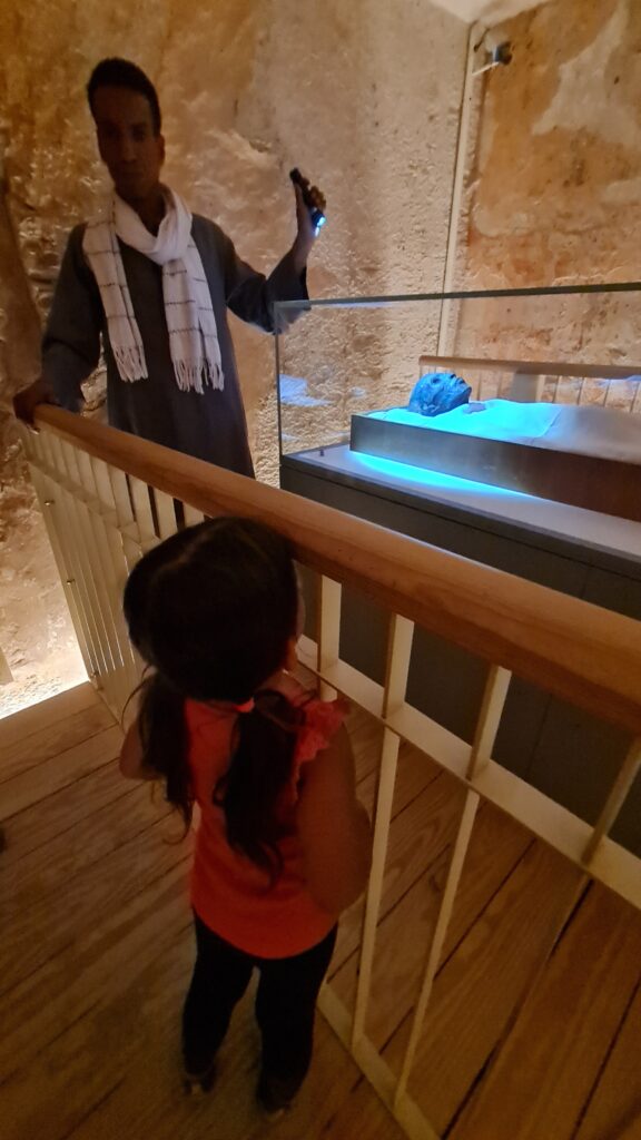 Um mini exploradora encantada com a múmia do faraó Tutancâmon