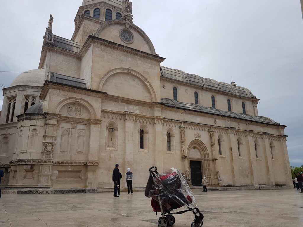Uma mochileirinha (protegida da chuva) no Banco de Braavos