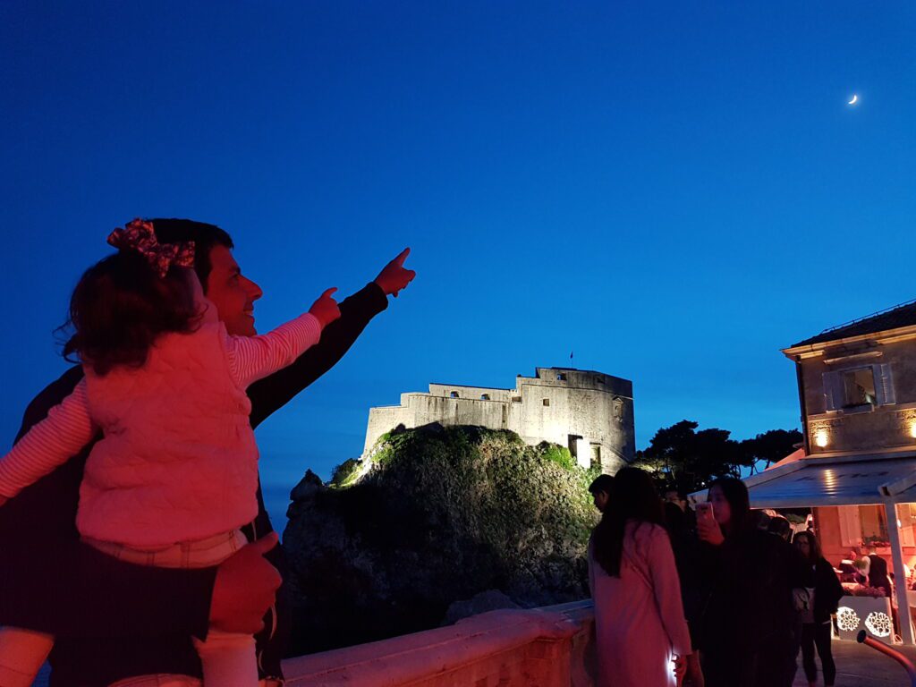 Dubrovnik é perfeita com e sem crianças: acredite, porque nós já testamos dos dois jeitos! Nina encantada com a lua sobre o Fort Lovrijenac